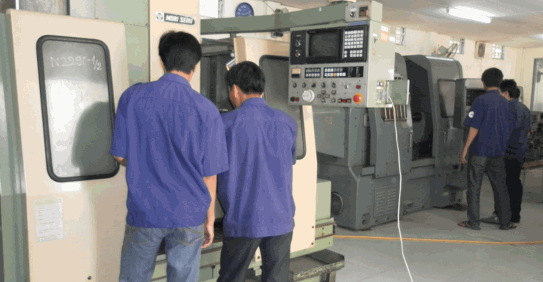 Công nhân đứng trực máy CNC